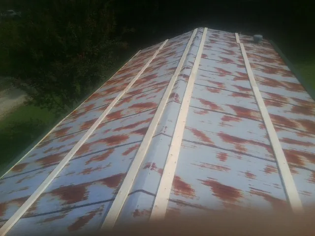 Rusted metal roof panels with new wood purlins before replacement — Storm Damage Roof Repair in Cheyenne by Roofing Brothers
