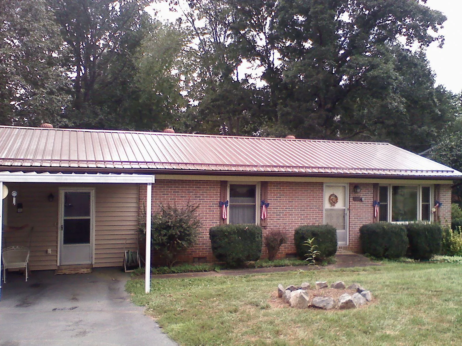 Bronze metal roof and carport on a brick ranch home — Roof Repair work by our crew in Cheyenne